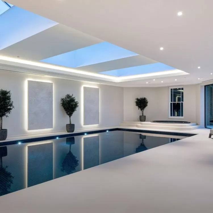 A large indoor exercise lap pool with a skylight above it