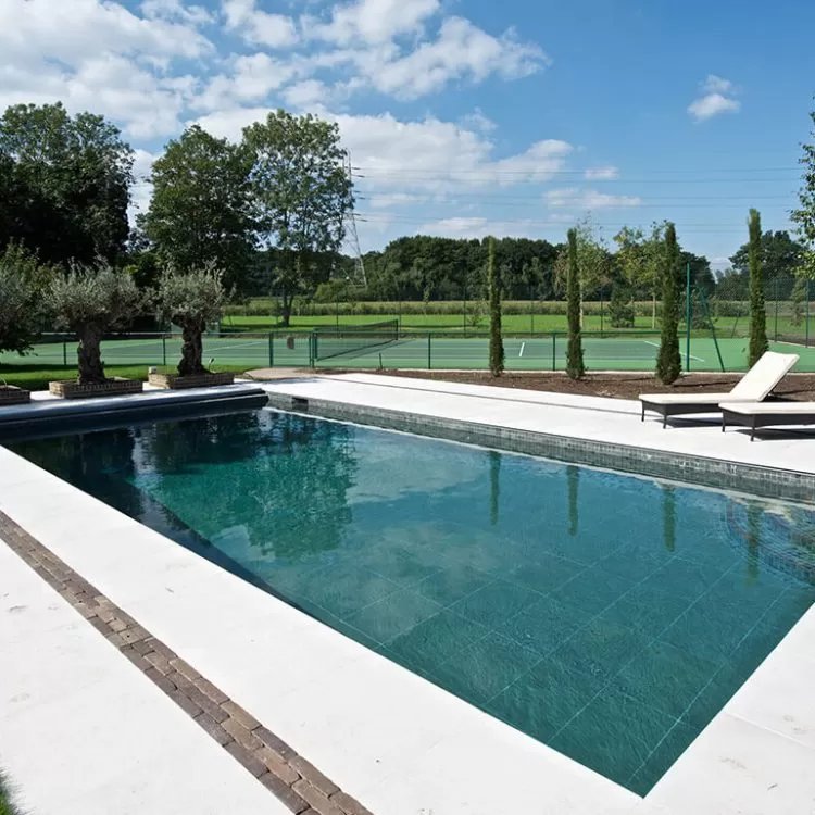 A classic outdoor luxury pool next to a tennis court